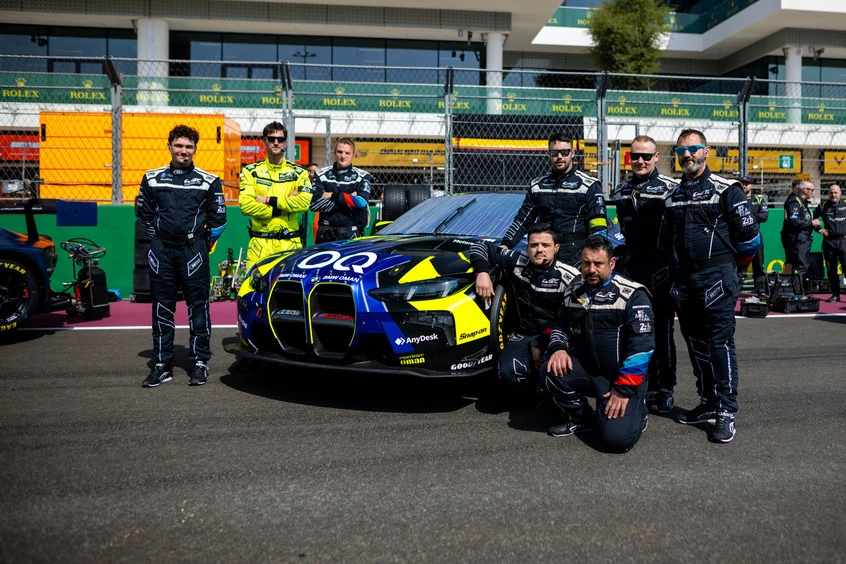 Bastien et son équipe de mécaniciens devant la BMW M4 GT3 officielle